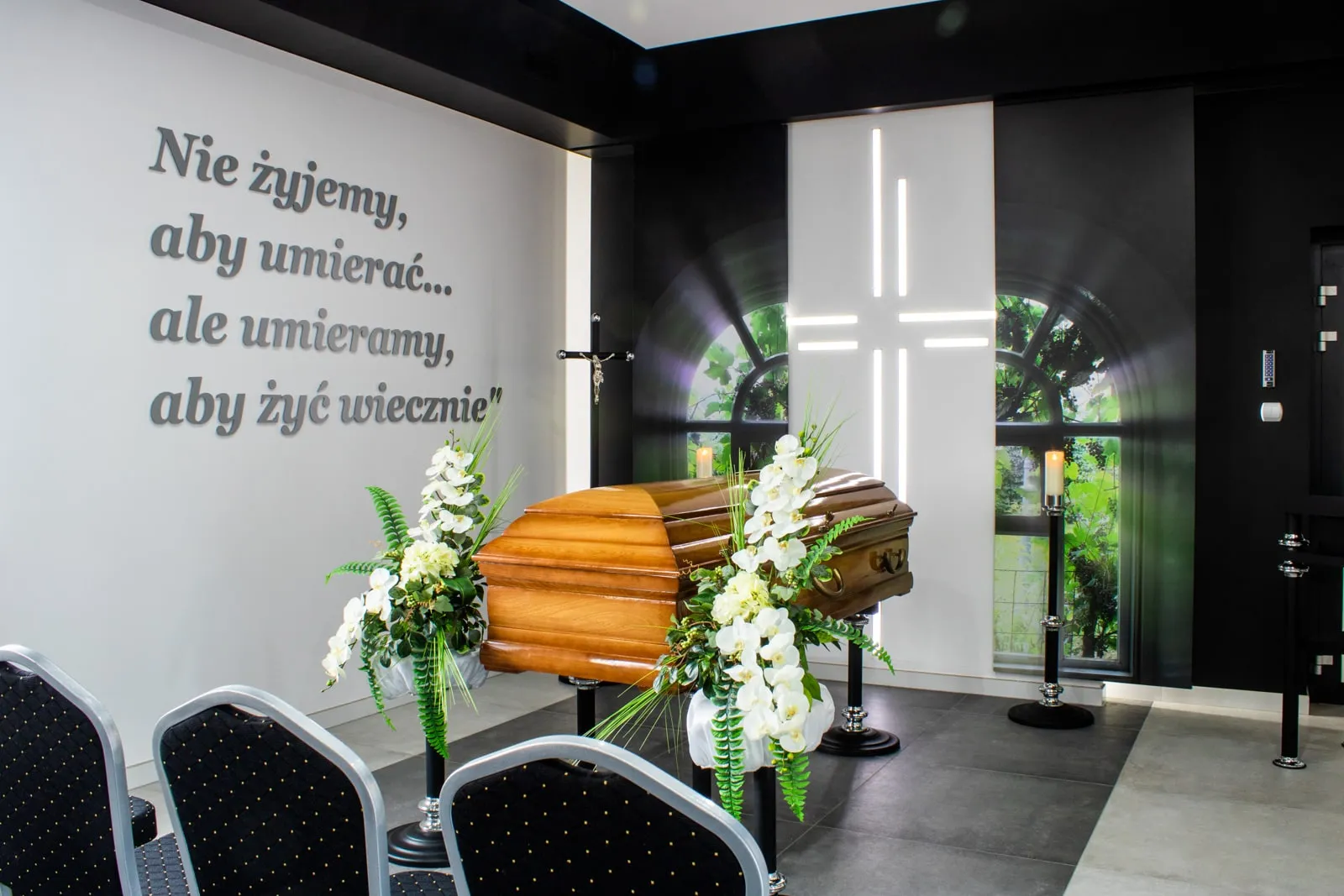 Trumna w kaplicy, w otoczeniu białych kwiatów